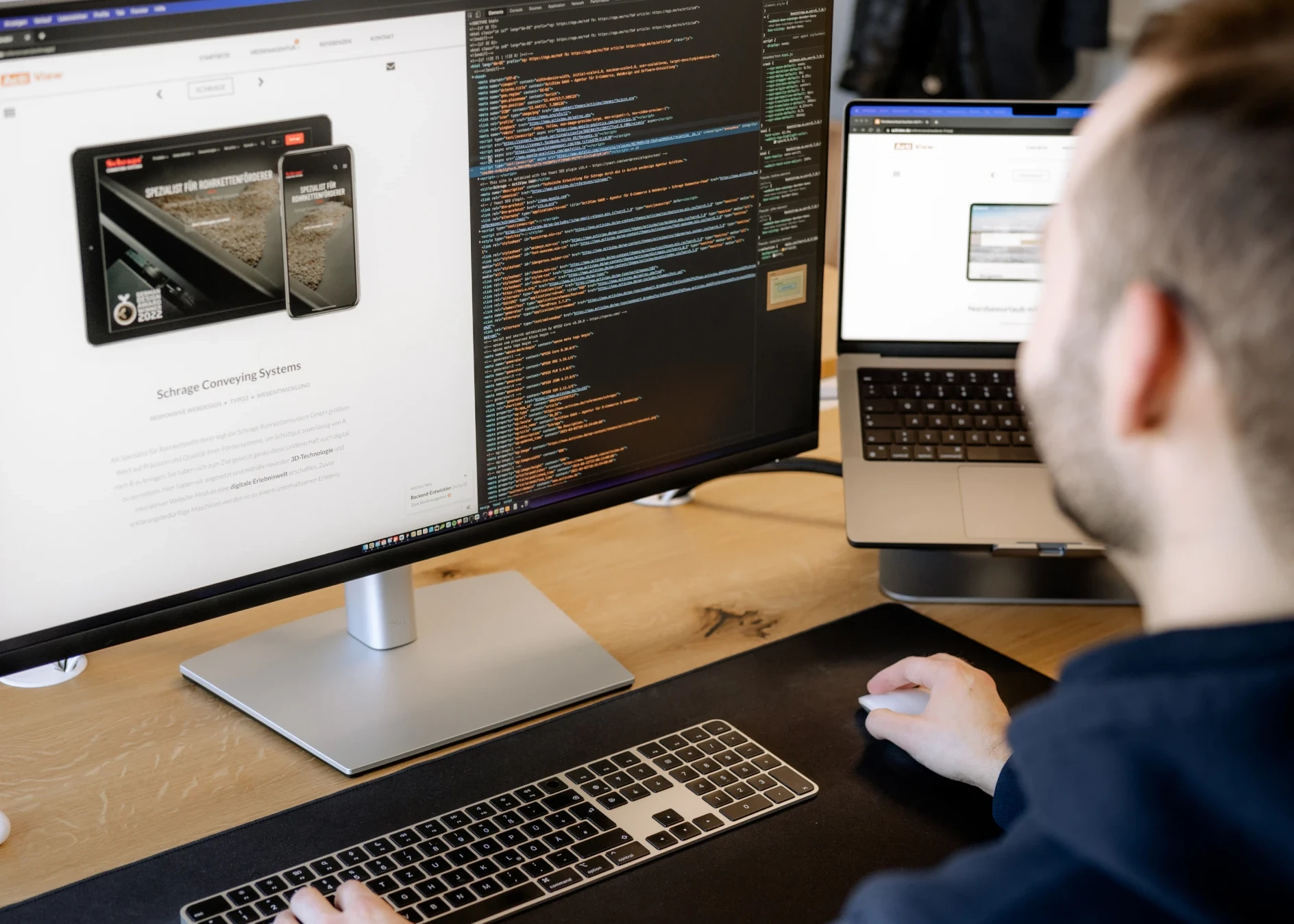Webentwickler beim Code-Debugging auf Laptop und großem Bildschirm