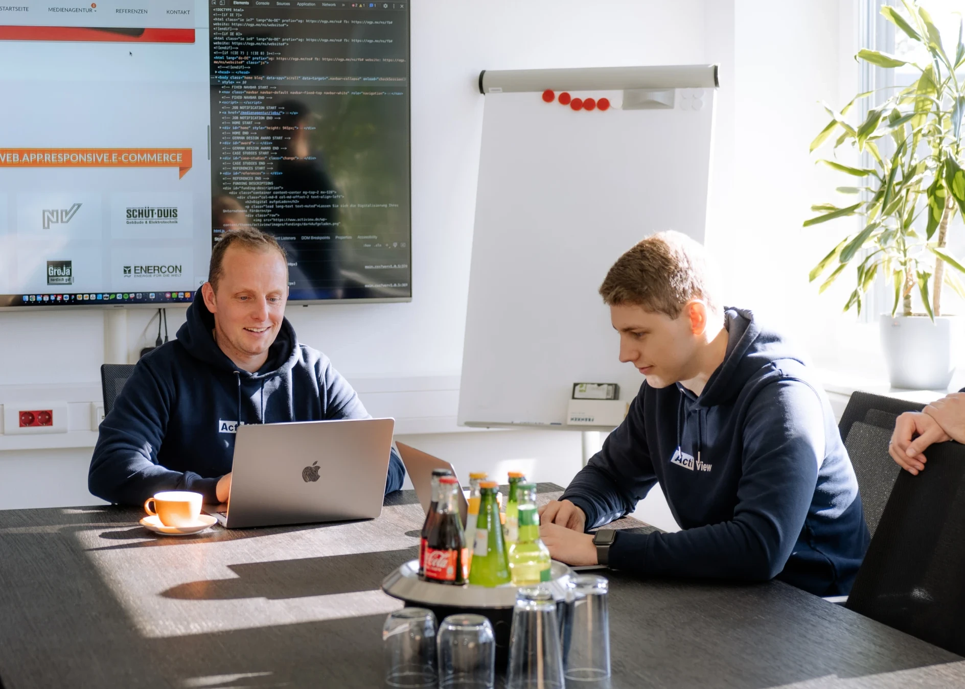 Zwei Mitarbeiter arbeiten gemeinsam an einem Projekt im Besprechnungsraum