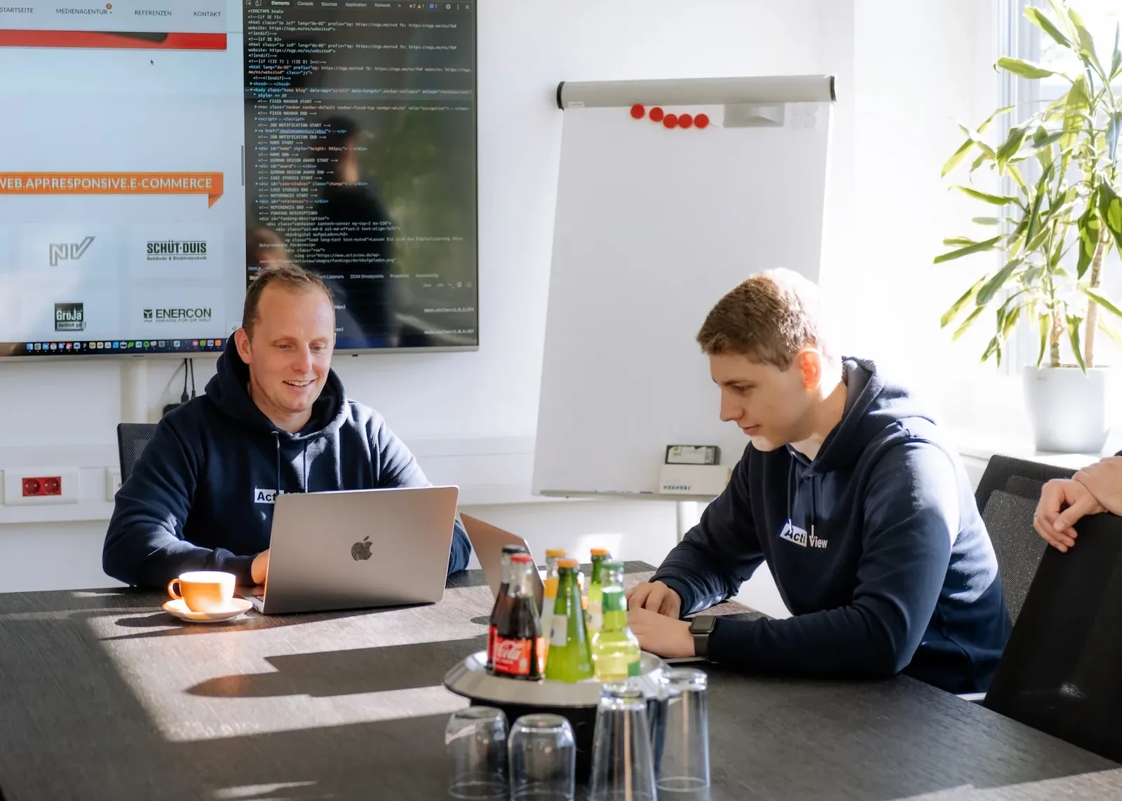 Zwei Mitarbeiter arbeiten gemeinsam an einem Projekt im Besprechungsraum