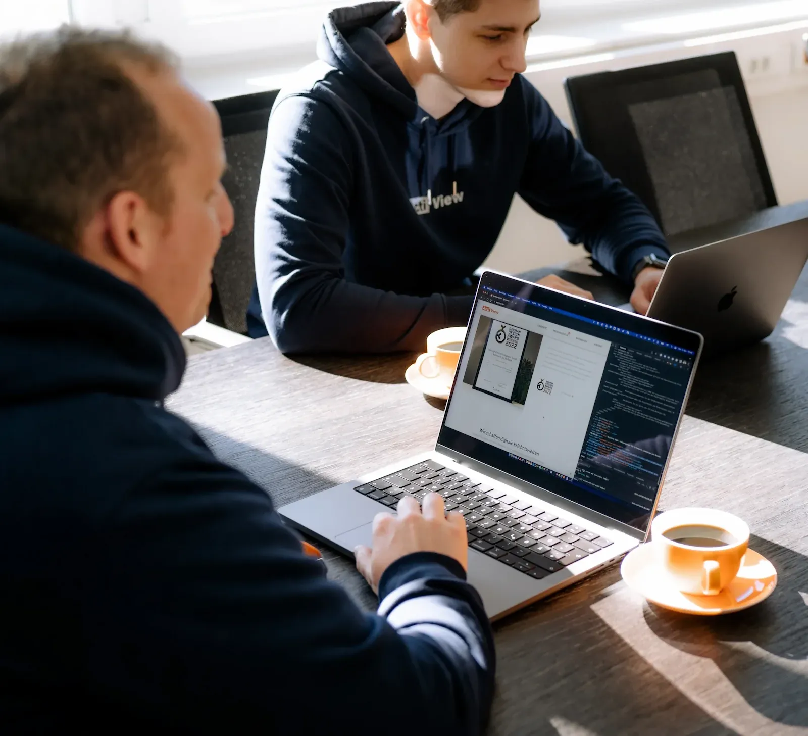 Zwei Mitarbeiter arbeiten gemeinsam an einem Projekt im Besprechungsraum